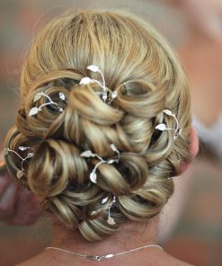 Bride with large curled bun with Grecian style headdress hair pins scattered through the design