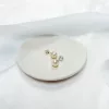 Traditional classic freshwater pearl stud earrings in silver set on a small ivory dish with blue ribbon