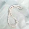 Traditional string of pearls bridal necklace set on a fabric background with blue ribbon