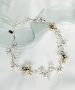 floral hair vine with freshwater pearls, leaves and flower accents set on a gold wire vine. The background is ivory fabric with blue silk ribbon.