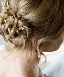 Dawn Chorus Hair pins. Bride with blonde hair in a messy bun with floral and leaf hairpins scattered through.