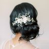 Bride with messy bun and dark hair wearing a Statement romantic floral comb set to the side behind the ear