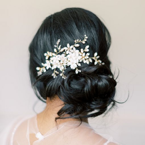 Bride with messy bun and dark hair wearing a wedding comb set to the side behind the ear