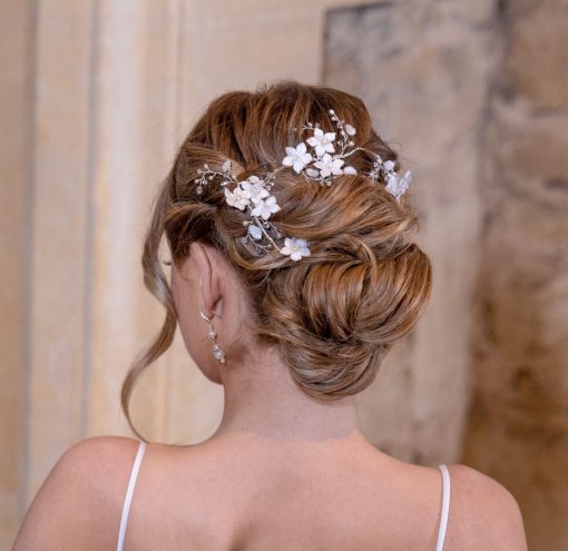 Clematis Bridal Halo intertwined into the hair of a bride with a her blonde hair up in a loose bun.