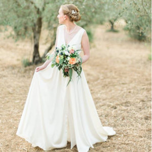 Bride stands outside among trees in a garden