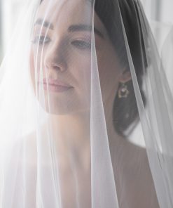 Bride wearing a veil over her face wearing gold pearls