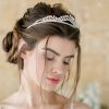 Bride looking down against a stone wall backdrop. The main focus is the Real Pearl Bridal Tiara that she is wearing in her hair.