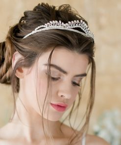 Bride looking down against a stone wall backdrop. The main focus is the Real Pearl Bridal Tiara that she is wearing in her hair.