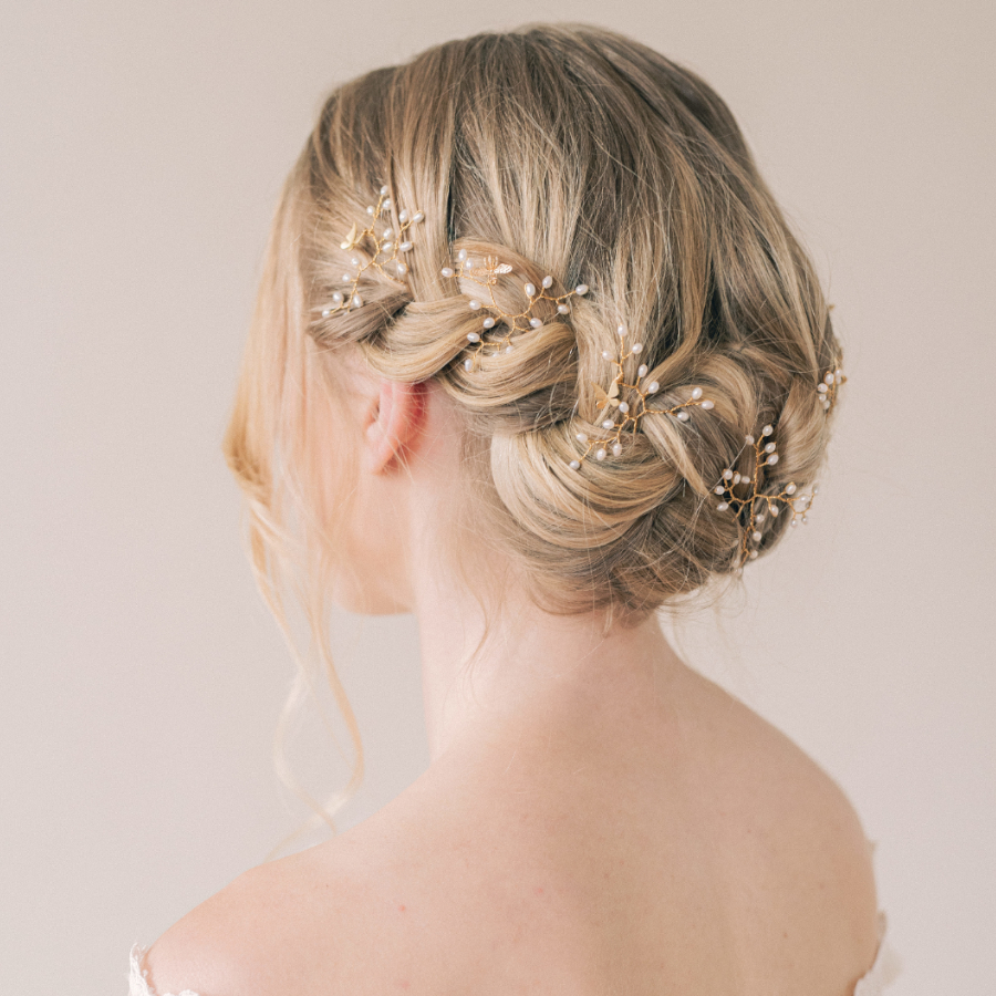 Image shows a bridal hair braid with hair up and small Unique bee and butterfly wedding hair accessory hair pins with pearls decorating the braid.
