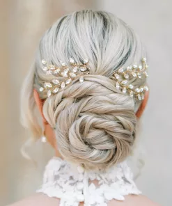 Bride with blonde hair in low spiral bun with two diamante crystal bridal hair pins. She is looking away from the camera, and has a choker style neckline to the dress with lace.