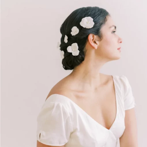 Delilah Hair Pins - Bride looking away from camera with hair up and a scattering of flower pins