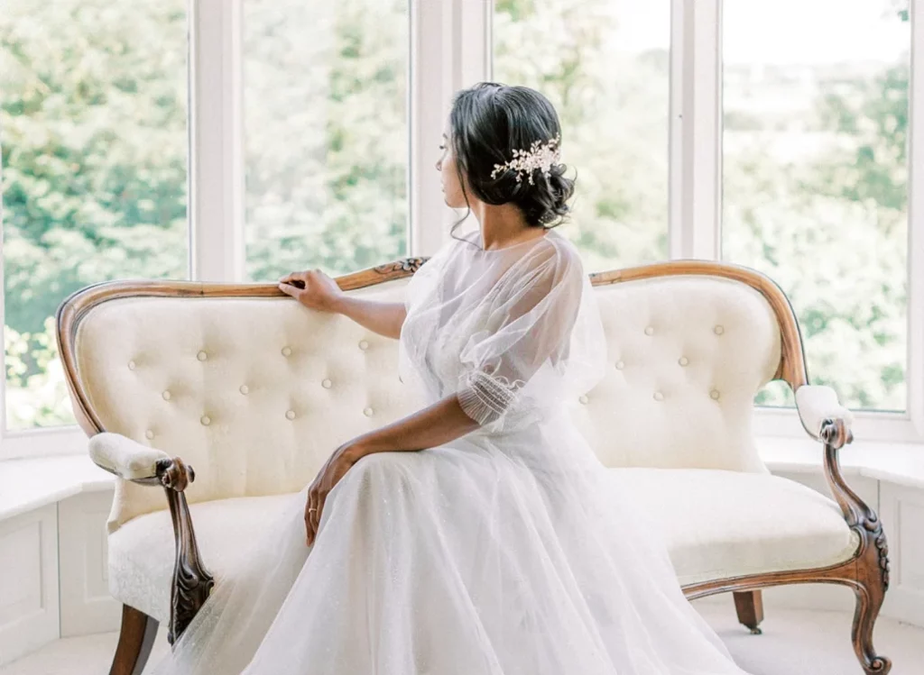 Chaise longue in window with bride sitting on it looking out of the window