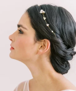 Image of woman with hair up in low bun wearing a star hair vine