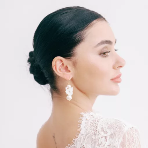 Tallulah Clustered Flower Pearl Earrings being worn by a woman with her hair up in a neat low bun.