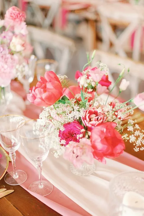 Display of large pink flowers on a wedding breakfast table