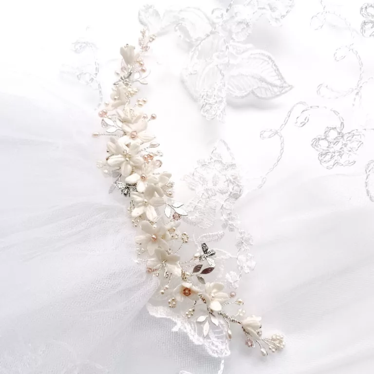 clay flower, pearl and crystal headdress sat on an embroidered white veil showing how to repurpose meaningful jewellery or accessories for your wedding with the brides mothers veil.