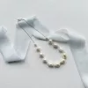 Chunky large baroque pearl bridal necklace set on a cream flat background with light blue silk ribbon.