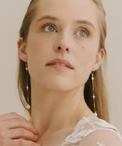 Long drop pearl bridal earrings being worn by a bride