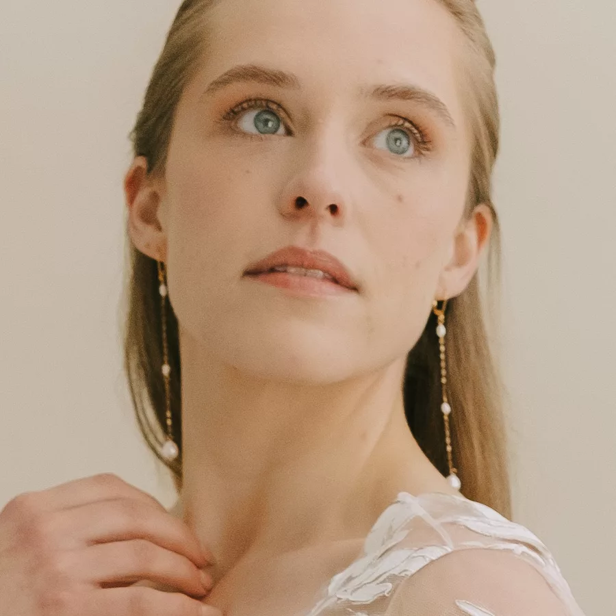 Long drop pearl bridal earrings being worn by a bride