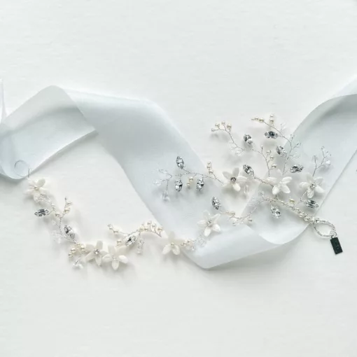 wrap around bridal blossom pearl hair vine resting on a white background with light blue silk ribbon.