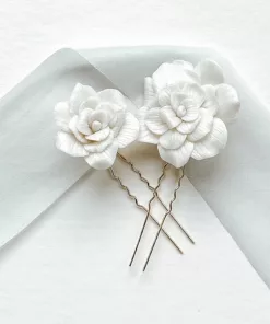 wedding handmade floral hair pins in gold set on a white background with light blue silk ribbon.